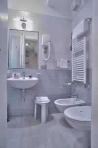 W łazience znajduje się umywalka, toaleta i lustro. w obiekcie Domus Pacis Assisi w Asyżu