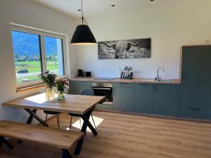 a kitchen with a table and a sink and a table and a table sidx sidx at Servus in der Wiesenstrasse inklusive Chiemgaukarte in Ruhpolding