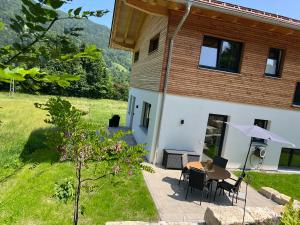 a patio of a house with a table and chairs at Servus in der Wiesenstrasse in Ruhpolding