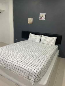 1 cama con edredón blanco y negro en un dormitorio en Mata'home, en Pattaya South 5 fotos más