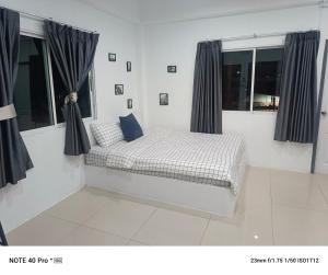 Cama en habitación con ventanas en Mata'home, en Pattaya South