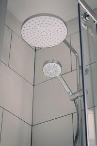 a shower with a shower head in a bathroom at Guardbridge Inn in St. Andrews +54 photos