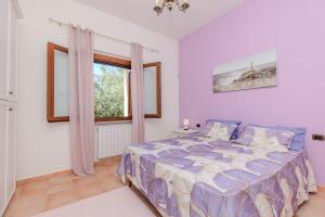 a bedroom with a bed and a window at Delizioso Appartamento San Teodoro Lu Fraili in San Teodoro