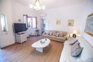 a living room with a couch and a tv at VILLINO DOLCE VITA - a 40 mt dal mare in LIDO DI ENEA - Ombrellone in spiaggia privata in Terracina