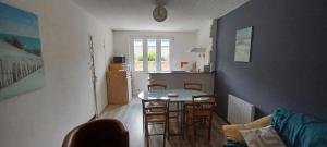 a kitchen with a table and chairs in a room at Ty sioul in Crach