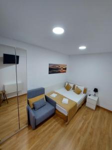 ein Zimmer mit einem Bett und einem Stuhl darin in der Unterkunft MI CASA ES TU CASA in Hospitalet de Llobregat