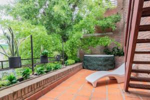 une terrasse avec un banc blanc et un arbre dans l'établissement Fliphaus Villa Salvador 4600 - 5 Bd Unique Villa Pool & BBQ Plaza Armenia, à Buenos Aires