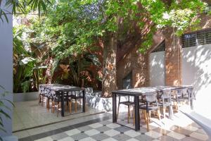 un groupe de tables et de chaises à côté d'un arbre dans l'établissement Fliphaus Villa Salvador 4600 - 5 Bd Unique Villa Pool & BBQ Plaza Armenia, à Buenos Aires