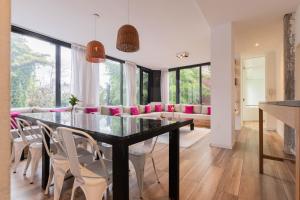 une salle à manger avec une table en verre et des chaises blanches dans l'établissement Fliphaus Villa Salvador 4600 - 5 Bd Unique Villa Pool & BBQ Plaza Armenia, à Buenos Aires 22 autres photos