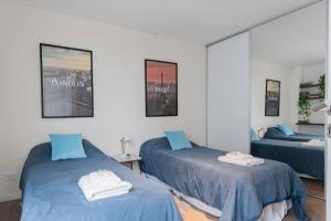 une chambre avec deux lits et un miroir dans l'établissement Fliphaus Salvador 5879 'A' 4 Bd BBQ & Pool Palermo, à Buenos Aires