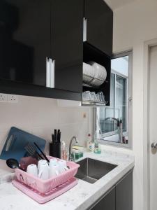 a kitchen with a sink and a pink tray on a counter at Savanna Executive Garden by Define Suite in Kampung Dengkil +44 photos