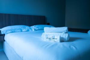 a white bed with blue pillows and a sign on it at MIA HOME experience in Milan