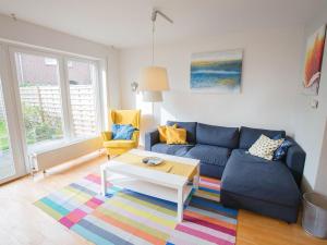 un salon avec un canapé bleu et une table basse dans l'établissement Ferienhaus Heineke, FeWo Vermittlung Nordsee, à Dangast
