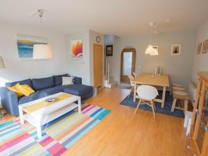 un salon avec un canapé bleu et une table dans l'établissement Ferienhaus Heineke, FeWo Vermittlung Nordsee, à Dangast