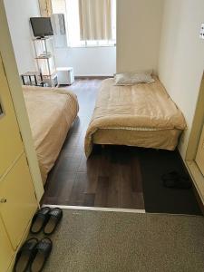 a small room with two beds and a pair of shoes at Tokyo 2beds room in Shinjuku Sanchome in Tokyo
