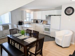 a kitchen and dining room with a table and chairs at Hébergement Harvey in Alma