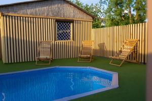 two chairs and a swimming pool next to a fence at Нептун in Gribovka