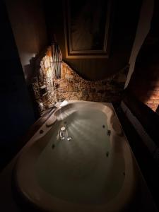 a bathroom with a bath tub in a room at Cantinhos da Mata Suítes Rústicas de Luxo Serra do Cipó MG in Serra do Cipo