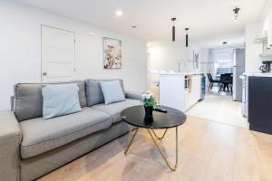 ein Wohnzimmer mit Sofa und Tisch in der Unterkunft Longueuil New Stylish 3-BDR free parking close to Dix 30&DT in Longueuil
