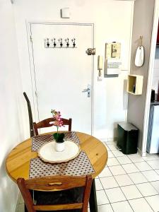 een houten tafel met een vaas met bloemen erop bij La Cabane de Riva Bella in Ouistreham