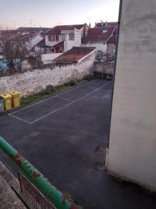 Una cancha de tenis en un estacionamiento con edificios. en L'Escale champenoise 2 wifi and parking free, en Châlons-en-Champagne