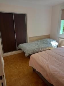 Un dormitorio con dos camas y una ventana. en L'Escale champenoise 2 wifi and parking free, en Châlons-en-Champagne