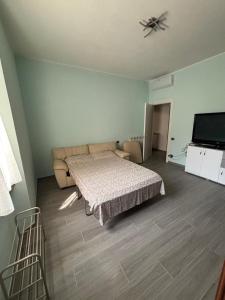 Un dormitorio con una cama, un sofá y un televisor. en Casa Palace, en Certaldo