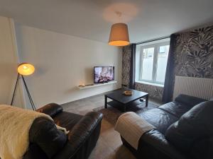 a living room with a couch and a table at Chambre 1P à Saint Hubert in Saint-Hubert