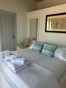 a bedroom with a white bed with towels on it at Simos suites in Elafonisos