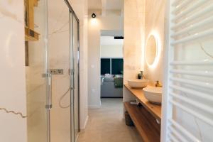Un baño con ducha de cristal y lavabo. en La Bali, Luxe et relaxation, en La Ferté-Gaucher