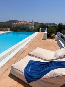 a pool with chaise lounge chairs next to a swimming pool at Simos suites in Elafonisos