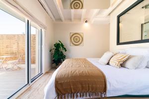 Un dormitorio con una cama grande y un balcón. en La Bali, Luxe et relaxation, en La Ferté-Gaucher