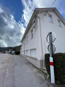 Appartement La Vanne Confortable et équipé في لابريس: مبنى ابيض امامه عداد مواقف السيارات