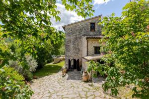 an external view of a stone building with trees at Respiro Umbria, 1500s Villa with Unique Biopool in Spoleto