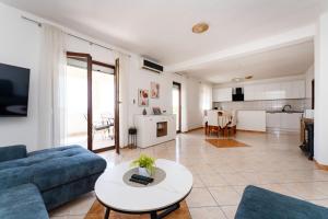 マスレニツァにあるMY DALMATIA - Holiday home Anatea with sea view terraceのソファとテーブルのあるリビングルーム