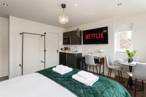 a bedroom with a bed and a kitchen and a table at The Bramble at The Balfour by Coorie Doon Stays in Milton of Balgonie