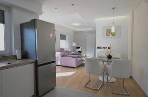 a kitchen and living room with a stainless steel refrigerator at Apartment Cobco in Kostrena