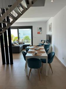 Un comedor con una mesa y sillas blancas. en Chulera Beach townhouse sea views, en Manilva