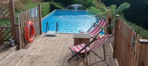 a deck with two chairs and a swimming pool at B&B TERRA DI COLLINA Relais-biker friendly-pool-sauna-jacuzzi in Montegrosso dʼAsti