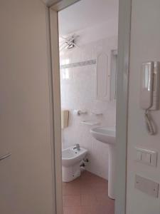 a white bathroom with a sink and a toilet at Petit Biscuit - Wi-Fi - Kitchen - AC - Parking in Lido di Camaiore +11 photos