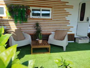 a patio with two chairs and a coffee table at Caravana en la huerta in Tiñosa Alta