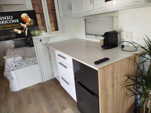 a small kitchen with a counter and a microwave at Caravana en la huerta in Tiñosa Alta +15 photos