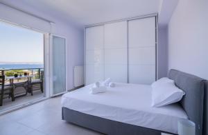 Un dormitorio blanco con una cama y una ventana grande. en Serenity Boutique Apartments, en Eantio 76 fotos más