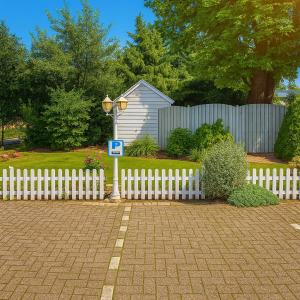 a white fence with a sign in front of a house at Historische gelegen appartement more Days in Dedemsvaart