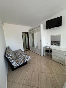 a living room with a couch and a tv and a desk at Vila Matei in Techirghiol