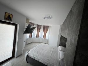 a bedroom with a bed and a large window at Vila Matei in Techirghiol