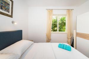 a bedroom with a white bed and a window at MY DALMATIA - Vacation house Maslenica with sea view terrace in Šarić