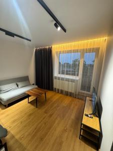 a living room with a couch and a table at Aleksandra Apartment in Ventspils