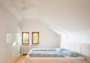 a white bedroom with a bed with blue pillows at Ferienhaus Möwe in Überlingen