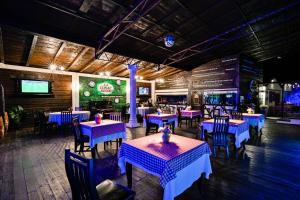 a dining room with blue tables and chairs with purple tables at La Conac Resort in Hulubeşti
